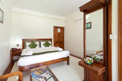 a bedroom with a bed and a mirror at Le Celestium in Munnar