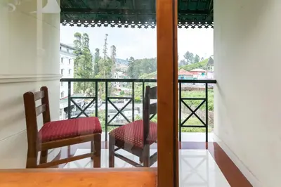 a balcony with two chairs and a view at Le Celestium in Munnar
