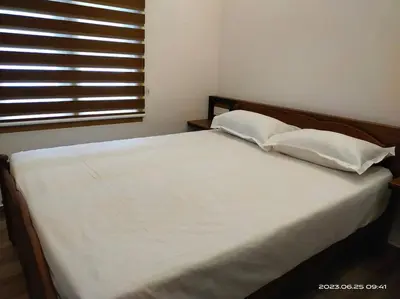 a white bed with two pillows and a window at Merlys Fruit Garden - Resort at Thattekkad in Kotamangalam