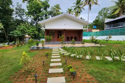 a house with a garden in front of it at Merlys Fruit Garden - Resort at Thattekkad in Kotamangalam