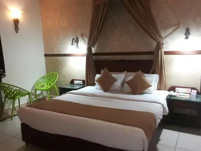 a hotel room with a large bed and two chairs at KTDC Tea county in Munnar