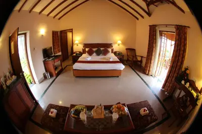 a bedroom with a bed and a table with shoes on it at KTDC Tea county in Munnar