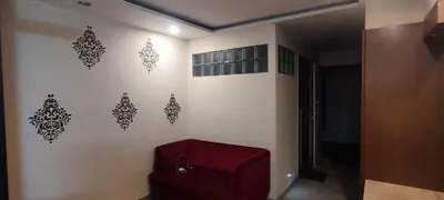 a room with a red chair and a wall with stencils at Happy Vibes studio flats - service apartment in Mysore