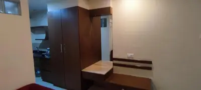 a kitchen with brown cabinets and a counter top at Happy Vibes studio flats - service apartment in Mysore