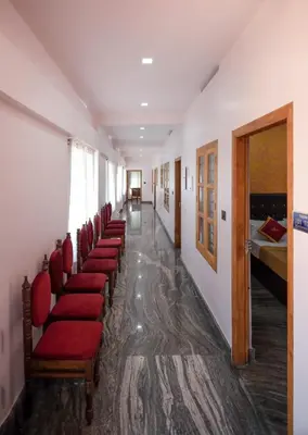 a row of red chairs in a hospital corridor at Hotel Wayanad Stay in Kalpetta