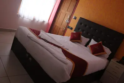 a bed with two pillows on it in a room at Hotel Wayanad Stay in Kalpetta
