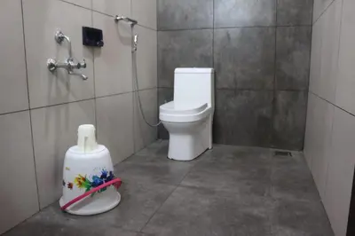a bathroom with a toilet and a roll of toilet paper at Hotel Wayanad Stay in Kalpetta
