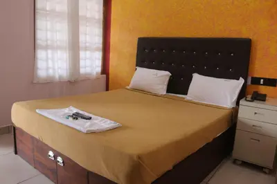 a bedroom with a large bed with a black headboard at Hotel Wayanad Stay in Kalpetta