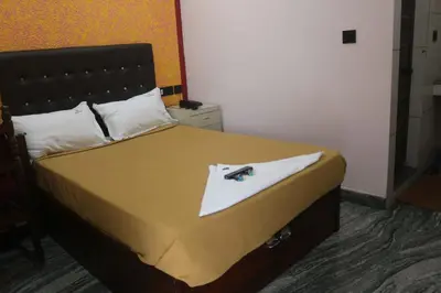 a bedroom with a bed with a white towel on it at Hotel Wayanad Stay in Kalpetta