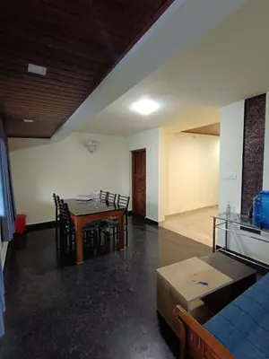 a living room with a table and chairs and a couch at High shine Homestay in Meppādi