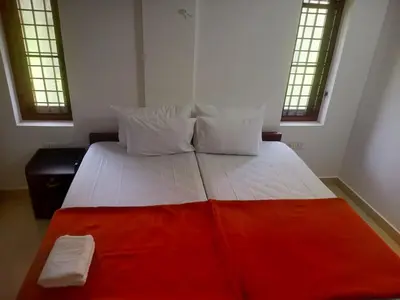 a bedroom with a large bed with a red blanket at Grace Mary Residency in Nedumbassery