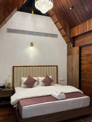 a bedroom with a large bed with a chandelier at Boulevard Resorts in Kakkadampoyil