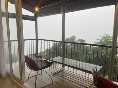 a screened in porch with a table and chairs at Boulevard Resorts in Kakkadampoyil