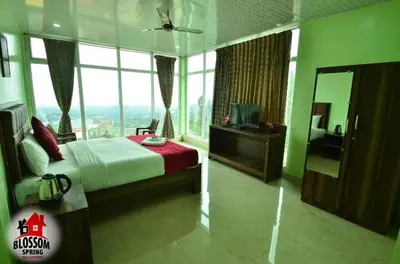 a bedroom with a bed and a large window at Blossom Spring Villa in Ooty