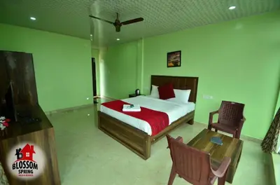 a bedroom with a bed and a table and a chair at Blossom Spring Villa in Ooty