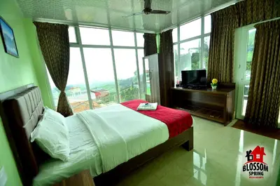 a bedroom with a bed and a large window at Blossom Spring Villa in Ooty