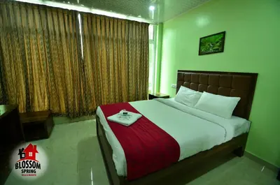 a bedroom with a large bed with a red blanket at Blossom Spring Villa in Ooty