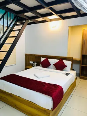 a bedroom with a large bed with red pillows at Regalia Wayanad in Kalpetta