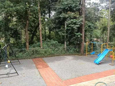 a playground with a blue slide in a park at Regalia Wayanad in Kalpetta
