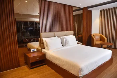 a bedroom with a large bed and a chair at THE PEARL VIEW HOTEL in Mulappilangād
