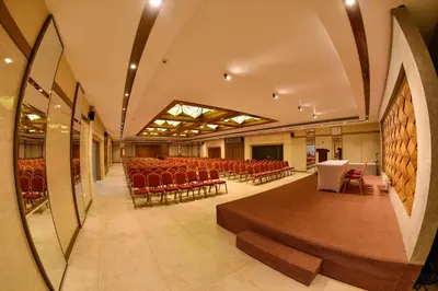an empty hall with red chairs and a stage at THE PEARL VIEW HOTEL in Mulappilangād
