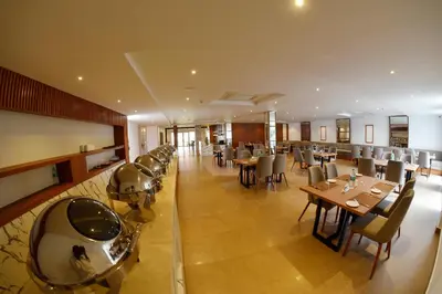 a dining room with tables and chairs in a restaurant at THE PEARL VIEW HOTEL in Mulappilangād