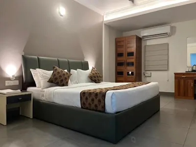 a bedroom with a large bed in a room at Nexstay Kassaba Inn in Kozhikode