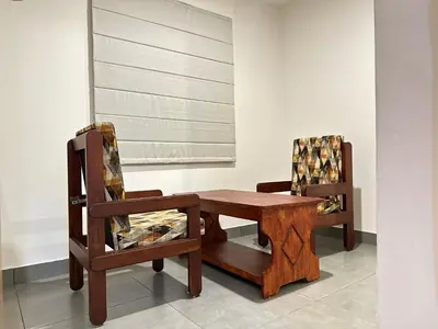 a wooden table and a chair in a room at Nexstay Kassaba Inn in Kozhikode