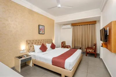 a hotel room with a bed and a tv at Nexstay Kassaba Inn in Kozhikode