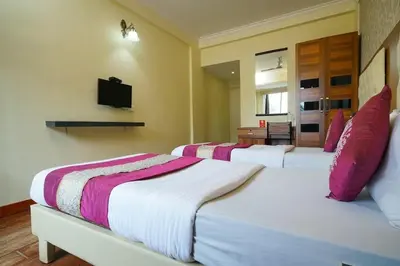 a bedroom with three beds with pink and white sheets at Nexstay Kassaba Inn in Kozhikode