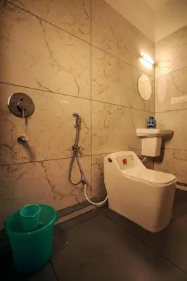 a bathroom with a shower and a toilet and a sink at Redstone Villa in Tāzhekkod