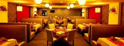 a restaurant with tables and chairs in a room at Paravoor Galaxy Hotel in Cherai Beach