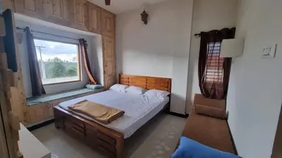 a small bedroom with a bed and a window at Sandiago Villa 2 Bhk House in Ooty