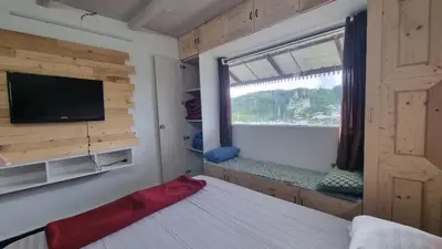 a bedroom with a bed with a window and a tv at Sandiago Villa 2 Bhk House in Ooty