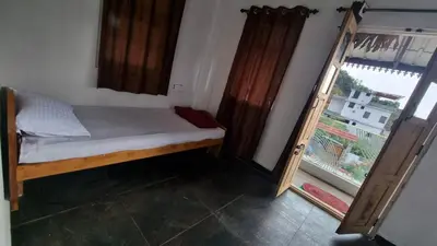 a small bed in a room with a window at Sandiago Villa 2 Bhk House in Ooty