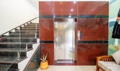 a hallway with stairs and a elevator in a building at Treebo The Rove with Swimming Pool in Madikeri