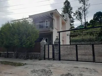 a house with a gate and a fence at Ohm Shanthi Kudil in Kodaikānāl