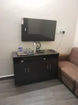 a living room with a tv and a couch at Ohm Shanthi Kudil in Kodaikānāl