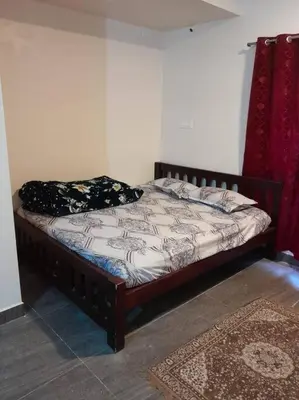 a bed sitting in a room with a bed sidx sidx sidx at Ohm Shanthi Kudil in Kodaikānāl