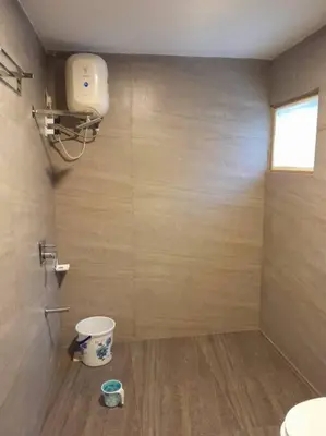 a bathroom with a sink and a toilet and a window at Ohm Shanthi Kudil in Kodaikānāl
