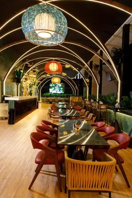 a dining room with tables and chairs and lights at Jenneys Residency in Coimbatore