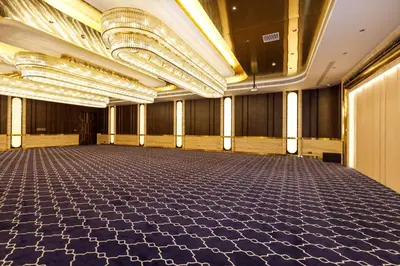 an empty ballroom with a large hall with chandeliers at Jenneys Residency in Coimbatore