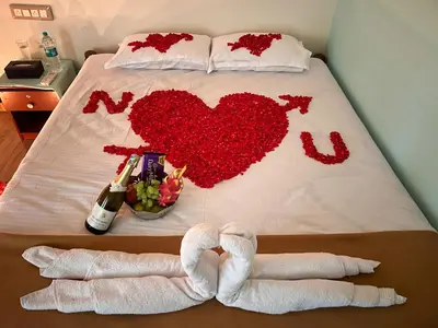 a bed with two towels and a bottle of champagne at Gandhada Goodu Retreat in Kanakapura