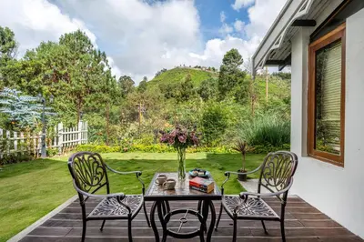 a table with a vase of flowers on a patio at The Winterfel in Yedapalli