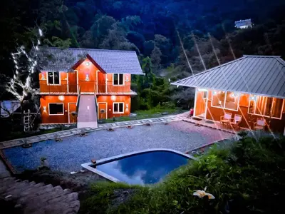 a house with a swimming pool in front of it at Don's River Valley Jungle Resort in Marayoor