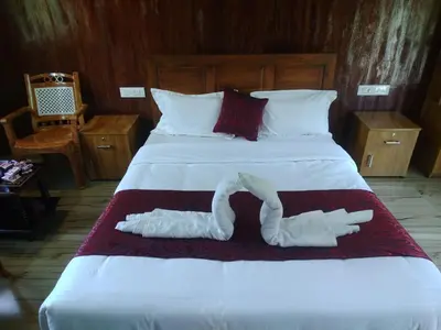 a large bed with two white towels on it at Don's River Valley Jungle Resort in Marayoor