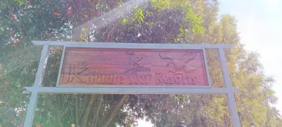 a sign that is in front of a tree at JK Nature Stay Resorts in Kanthalloor