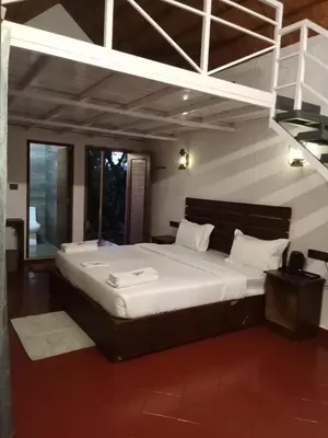 a bedroom with a large bed with white sheets at JK Nature Stay Resorts in Kanthalloor