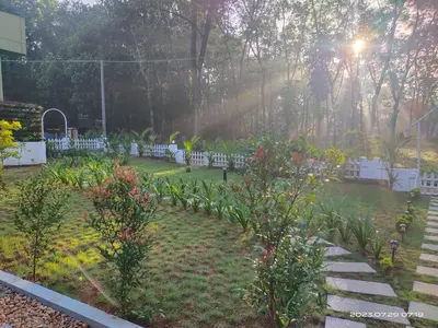 a garden with flowers and stairs in the yard at Family Cottage at Merlys Fruit Garden, Thattekkad in Kotamangalam