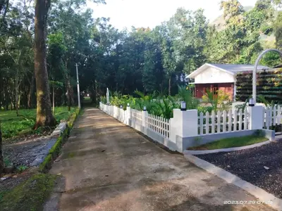 a white picket fence in front of a house at Family Cottage at Merlys Fruit Garden, Thattekkad in Kotamangalam